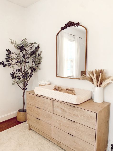 Olive tree with brass mirror. Simple changing table for nursery. Ivory and white. All Natural Wood Nursery, Ikea Natural Wood Dresser, Nursery Natural Wood Dresser, Neutral Changing Table, Neutral Nursery Minimalist, Natural Dresser Nursery, Neutral Nursery Furniture, Neutral Nursery Changing Tables, Modern Minimal Nursery