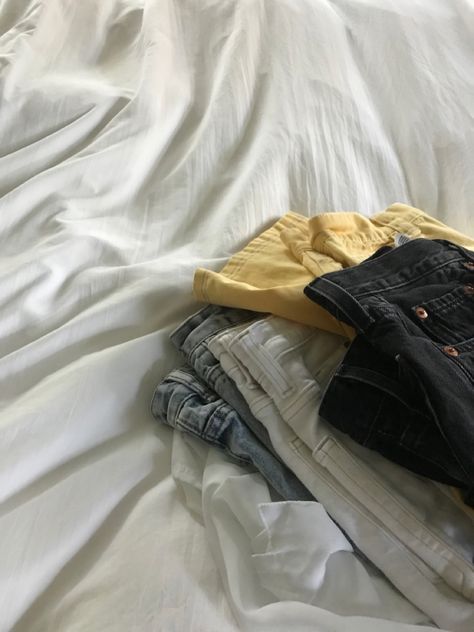 jeans folded on white bed Outfit On Bed Aesthetic, Outfit Layed Out On Bed, Clothes Folded Aesthetic, Clothes Laid Out On Bed Aesthetic, Clothes On Bed Aesthetic, Clothes Pile Aesthetic, Clothing Pile Aesthetic, Folded Clothes Aesthetic, Made Bed Aesthetic