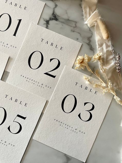 These A5 table names are the perfect personalised addition to your tables. Whether for a wedding or event, personalise your table numbers with your required text and add the finishing touches to your tablescape. These add a modern twist to a classic, simplistic feel. Creating a timeless aesthetic to your event.  D E T A I L S - Each table number is individually designed, bespoke to you.  - Table numbers are printed on high quality 300gm2 textured card, giving a luxe premium feel. - Each table nu Cute Table Numbers, Wedding Hanging Table Numbers, Wedding Design Table, Black Tie Table Numbers, Simplistic Wedding Ideas, Modern Wedding Inspiration Decor, Chic Wedding Table, Classic Table Numbers, Table Numbering