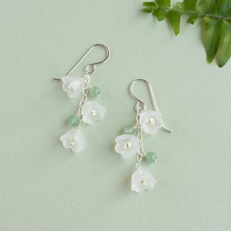 Our lily of the valley earrings will bloom all year.  Featuring creamy pearls encased in frosted white flowers, that dangle from sterling silver earrings.  The whimsical flowers are joined by green aventurine gemstones adding a touch of natural beauty.  Symbolizing sweetness and purity, the lily of the valley signifies a return to happiness.  Making the earrings a thoughtful and unique gift for a loved one, especially those with a fondness for the May birth month flower or nature-inspired jewelr Fimo, Green And Silver Earrings, May Birth Month Flower, Fairycore Jewelry, May Birth Flower, May Birth Flowers, Anting Manik, Whimsical Flowers, Jewelry Lookbook