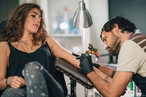 7 Surprising Things Tattoo Artists Wish You Knew After You Got A Tattoo Tattoo Pose Reference, Tattoo Artist Pose Reference, Tattoo Artist Pose, Getting Tattooed Photography, Person Getting Tattooed, People With Tattoos Photography, Getting Tattooed Aesthetic, Interacting Poses, Tattoo Artist Photography