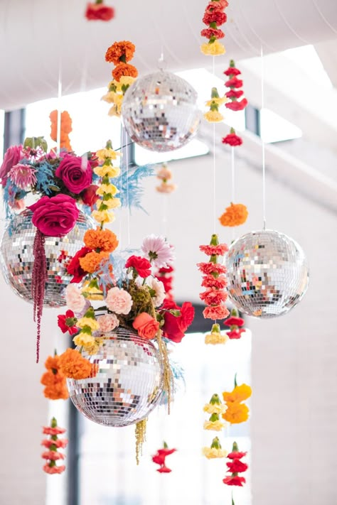 The Bride Wore A Blush Dress For This Colorful Disco Wedding Disco Ball And Flower Wedding, Hanging Flowers And Disco Balls, Disco Floral Aesthetic, Colorful Disco Ball Wedding, Disco Balls And Florals, Flowers And Disco Ball Party, Floral Arrangements Aesthetic, Garden Party Disco Ball, Floral Disco Ball Wedding