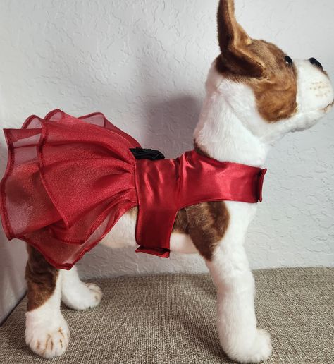 Introducing our Elegant Dog Dress, the perfect attire for pet parties and special occasions! This exquisite dress is made with the finest satin and organza materials, creating a stunning combination of red with black flower detail. Your beloved pet will surely feel like the star of the Christmas season with this elegant outfit.  Highlights: - Made with the finest satin and organza materials - Striking red dress with black flower detail - Perfect for pet parties and special occasions - Conforms to your pet's body for a comfortable fit Benefits: 1. Stand out in Style: Dress your pet in this elegant outfit to make them the center of attention at any event. The striking red dress combined with the black flower detail creates a visually stunning and fashionable look. 2. Superior Comfort: The sm Christmas Dog Dress, Dog Dress Pattern, Elegant Dog, Christmas Dress Up, Christmas Attire, Red Christmas Dress, Party Animals, Saree Blouse Designs Latest, Pet Dress