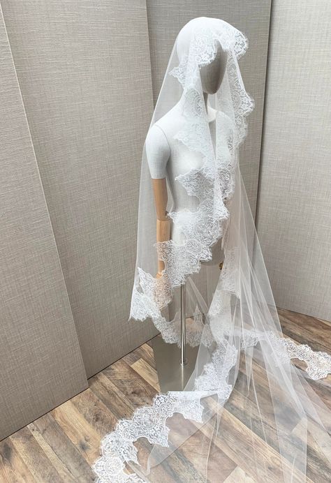 "This grand luxurious mantilla style veil features feminine vintage inspired Chantilly lace beautifully framing the face. This veil is made in the wider width insuring an elegant drape. The veil is secured in your hair with the comb on top of your head. The veil in the photos is a cathedral length and measures 110\" long from the hair comb to the bottom of the veil. Other lengths are available as well. The color of the veil is soft white and will compliment white, off white or light ivory dresses. * RETURN POLICY - We do not accept returns for a refund as all of out items are made to order. But please contact us if you are having an issue with your order. - We do accept exchanges. You can exchange your items for something else in our shop. The items you would like to exchange should be shi Long Veil Wedding Dress, Spanish Veil, Lace Trim Veil, Chantilly Lace Trim, Mantilla Veil Wedding, Lace Trimmed Veil, Spanish Mantilla, Mexican Lace, Catholic Veil