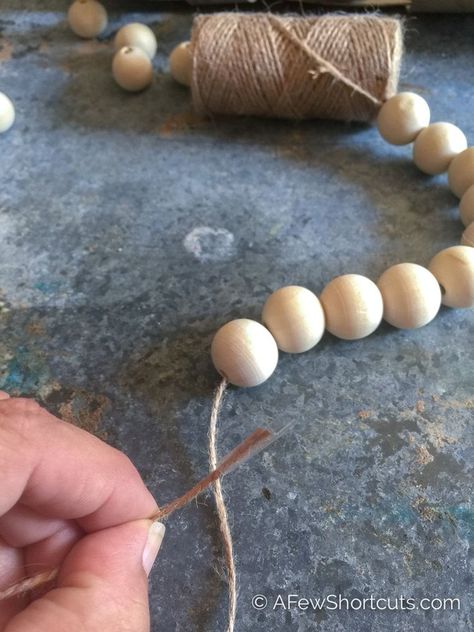 Skip the home decor store and learn how to make wooden bead garland with tassels for a fraction of the price. Perfect DIY for your Farmhouse decor and easy to make Wine Bottle Crafts, Wood Beads Diy, Farmhouse Beads, Wooden Bead Garland, Wine Bottle Diy Crafts, Bead Garland, Wood Bead Garland, Diy Farmhouse Decor, Mason Jar Diy