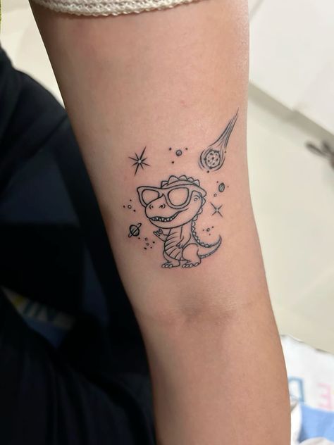 Funny Space Tattoo, Dinosaur Simple Tattoo, Mother Son Dinosaur Tattoo, Cute Dinosaur Tattoo Ideas, Cute Dino Tattoo Ideas, Funny Dinosaur Tattoo, Space Dragon Tattoo, Tiny T-rex Tattoo, Baby Dinosaur Tattoo