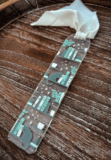 Bookmark details: ✔️1 acrylic bookmark with vinyl design.  ✔️Design is made with high quality, permanent adhesive vinyl & sealed with clear resin ✔️Chiffon ribbon is included in purchase.  ✔️Bookmark measures approximately 5.5" x 1.25". All items are made to order so shipping times may vary. Thank you! Clear Acrylic Bookmarks, Diy Acrylic Bookmark, Acrylic Bookmarks Cricut, Cricut Bookmark Ideas, Acrylic Bookmark Ideas, Clear Bookmarks, Cat Library, Library Bookmarks, Aesthetic Bookmarks