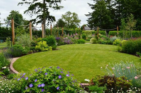 Circular lawns and timber posts support ropes on to which roses and clematis will climb country style garden by unique landscapes country | homify Circular Garden Design, Circular Garden, Circular Lawn, Unique Landscapes, Country Garden Design, Timber Posts, Lawn Design, Back Garden Design, Cottage Garden Design