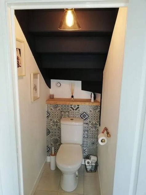 a small powder room under the stairs with a bold tile, a wooden shelf, some decor and a pendant lamp is a cool soluton for a tiny space Understairs Bathroom Downstairs Toilet, Small Lavatory Ideas, Small Understairs Bathroom, Half Bathroom Ideas Under Stairs, Under Stairs Wc, Wc Under Stairs, Toilet Under Stairs Ideas, Half Bath Under Staircase, Under Stair Toilet