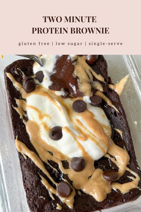 This healthy two minute protein brownie is gluten free, refined sugar free, low carb, low sugar, and high protein. On a small white plate is a single-serve protein brownie in the shape of a rectangle. The outside is a rich dark chocolate color looking soft, gooey in the center, pillowy, and fudgy. Some powdered monkfruit is white sprinkled on top. A fork has a bite on it showing the inside texture of soft, chewy, and airy. High Protein Snacks Desserts, Low Carb High Protein Recipes Desserts, Desserts With Chocolate Protein Powder, Body Fortress Whey Protein Recipes, Gluten Free Protein Brownies, Mint Chocolate Protein Powder Recipes, High Protein Quick Dessert, Healthy Sweet Protein Snacks, Desserts For Runners