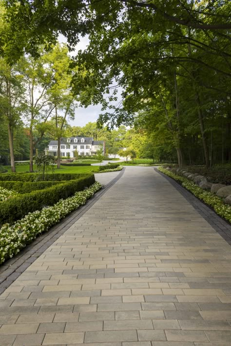 This driveway design idea is inspired by our Linea paver. This paving stone is available in three lengths and two widths for design dimensions that better suit you. Impress the guests with your landscaping by installing a single width to achieve a clean, crisp, linear look, or combine both for a stylish pattern. Check out our website to shop the look! Or, check out the estimation tool on our website to see how much a similar project could cost you! Driveway Design Entrance, Paved Driveway Ideas, Luxury Driveway, Driveway Paving Stones, Curb Stone, Driveway Entrance Landscaping, Entrance Landscaping, Paved Driveway, Driveway Pavers