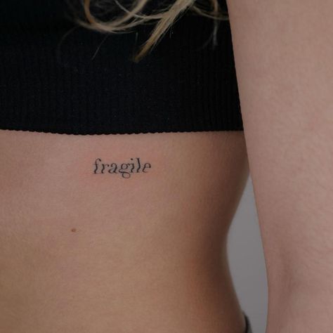 fragile tiny tattoo on rib feminine Most Feminine Tattoo Placement, Fragile Word Tattoo, Dainty Rib Cage Tattoos, Fragile Tattoo Words, Placements For Small Tattoos, Tattoo Placements For Women, Dainty Rib Tattoos For Women, Ribs Tattoo For Women, Fragile Tattoo