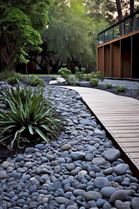 Create a stunning outdoor path with rocks, wood, and dark aquamarine and gray tones. Achieve a sleek and decorative look that is both lush and detailed, yet clean and simple. Grey Rocks Landscaping, Dark River Rock Landscaping, Garden With River Rocks, Grey Rock Landscaping, Gray Rock Landscaping, Front Yard Rock Landscaping, Yard Rock Landscaping, Backyard Flooring, River Rock Path