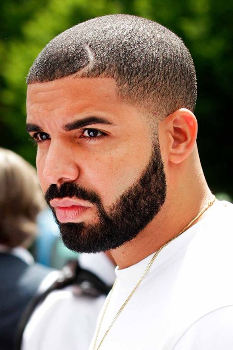 When you think of a Drake haircut, you can hardly name one only. The rapper changes his style pretty often. Among his most popular 2022 hair looks are Drake waves, a heart design, a line up and an Afro fade. Find more ideas here. #menshaircuts #menshairstyles #drake #drakehair #drakehaircut Drake Beard, Hair Parts, Hairstyles For Receding Hairline, Drake Photos, Buzz Cut Hairstyles, Boy Haircut, Investment Opportunities, Aubrey Drake, Black Men Haircuts