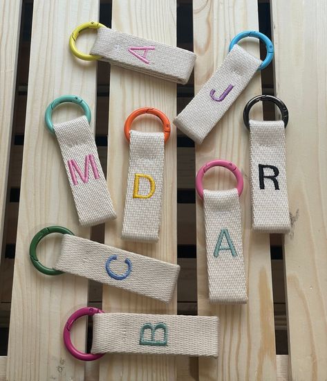 Show off your personality with this personalized embroidered keychain. Perfectly crafted with heavy-duty cotton webbing and a durable metal ring, you can customize the color of both the letter and ring to suit your style. Make a timeless statement with this unique accessory. customize yours! Only one letter per keychai Embroidered Keychains, Diy Projects To Make And Sell, Hand Beaded Embroidery, Embroidered Letters, Diy Embroidery Designs, Crewneck Sweaters, Machine Embroidery Projects, Personalized Letters, Embroidered Crewneck