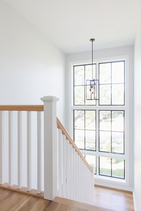 Floor-to-ceiling windows bring plenty of natural light to this stairway Wall paint color is Sherwin Williams Site White #stairway #windows #paintcolor Stair Case Windows, Windows On Staircase Wall, Stair Case Windows Design, Window Stairs Design, Stairway Window Ideas, Stairs Window Design, Stair Case Ideas, Window Stairs, Staircase Window