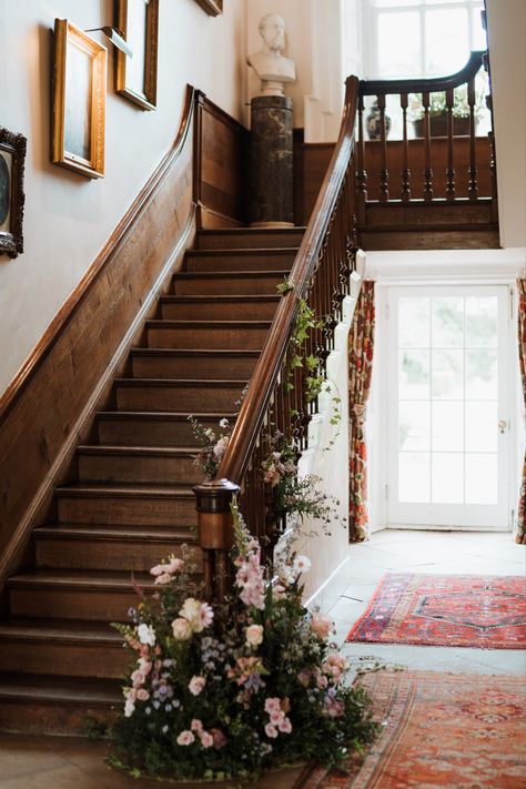 Greenery and pink flowers on staircase bannister for a wedding. Flower Garland Staircase, Wedding Flowers Staircase, Staircase Wedding Flowers, Staircase Florals Wedding, Greenery On Staircase, Staircase Flowers Wedding, Staircase Greenery, Staircase Florals, Staircase Flowers