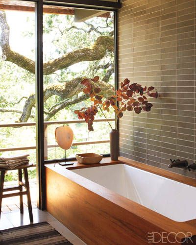 The tile in the master bath is by Heath Ceramics, and the antique stool is English; the enameled-steel tub is fitted with a custom-made teak surround and has oxidized Waterworks fittings. Tour the home here.    - ELLEDecor.com Powder Room With Tub, Bath By Window, Heath Ceramics Bathroom, Wood Spa Bathroom, Heath Tile Bathroom, Tub With Wood Surround, Enclosed Tub, Heath Ceramics Tile, Zen Bathroom Decor