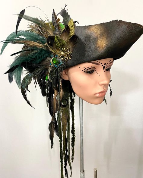 + + + Pirate Hat - Peacock + + + The pirate hat is made of aged premium woolfelt. It is adorned with various feathers, textile materials, branches, leaves, buttons and jewelry. Size -> Circumference of your head in cm + + +     + + + I create the hats, headdresses and masks in my studio "Maskenzauber & Erlebenskunst" in Berlin. Anyone who wants to visit me there is very welcome. Please make an appointment with me. Mask magic & experience art Marén Söhnlein m@skenzauber.de www.maskenzauber.com Pirate Hat Women, Pirate Tricorn Hat, Pirate Hat Diy, Diy Pirate Hat, Pirate Bride, Pirate Wedding Theme, Halloween Zoo, Fantasy Hat, Feathered Hat