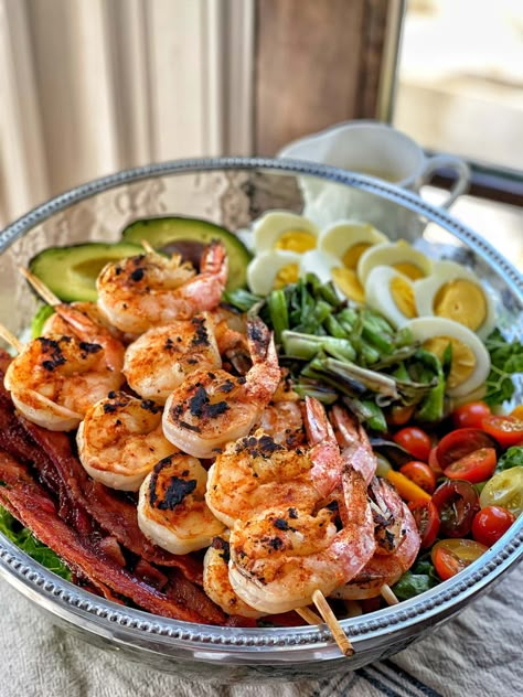 Forget takeout, make your own healthy cobb salad at home! This healthy grilled shrimp cobb salad is a twist on the classic, with all the best components. Crisp romaine lettuce is topped with colorful grape tomatoes, crispy cooked bacon strips, sliced hard boiled eggs, and avocado. Topped with flavorful skewers of grilled shrimp and the addition of a surprising ingredient: grilled scallions, this recipe is delicious and easy to make.  The creamy honey mustard homemade dressing is the grand finale Boiled Eggs And Avocado, Sweet And Savory Steph, Healthy Cobb Salad, Shrimp Cobb Salad, Creamy Honey Mustard, Sweet Savory And Steph, Eggs And Avocado, Salad At Home, Creamy Honey