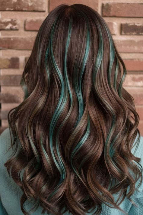 Warm brown waves are given a unique twist with teal highlights subtly woven throughout the hair. This stylish and modern look adds depth and dimension, perfect for anyone looking to add a pop of color to their everyday hairstyle. Teal And Brown Hair, Brown And Teal Hair, Teal Highlights In Brown Hair, Teal Hair Highlights, Highlights In Brown Hair, Teal Hair Color, Teal Highlights, Everyday Hairstyle, Teal And Brown