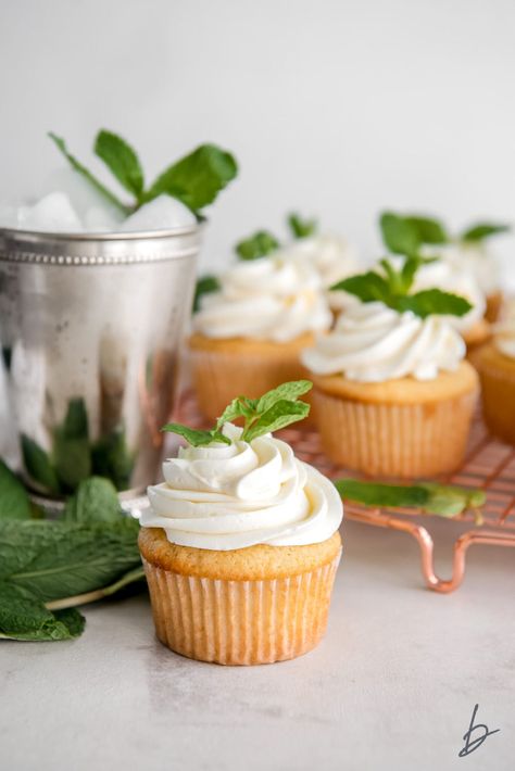 mint julep cupcake with frosting and mint leave garnish in front of silver mint julep cup and more cupcakes Kentucky Derby Desserts, Kentucky Derby Food, Kentucky Derby Recipes, Kentucky Derby Mint Julep, Derby Recipe, Cocktail Cupcakes, Derby Party Food, Mint Frosting, Kentucky Derby Party Food