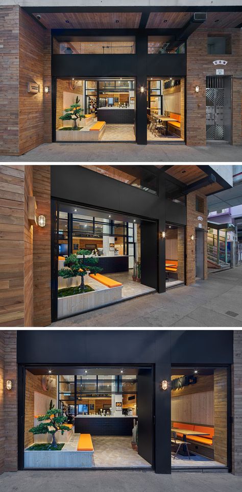 The facade of this modern coffee shop is open to the street and defined by a dual black door frame surrounded by wood. Awkward Corner, Shop Entrance, Restaurant Facade, Display Visual Merchandising, Modern Coffee Shop, Tiered Seating, Retail Facade, Shop Door, Shop Facade