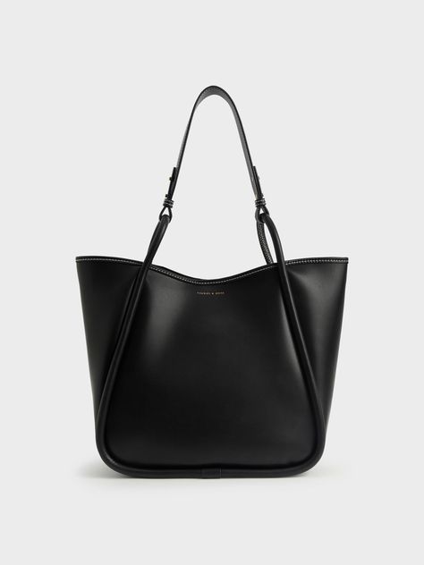 Elegance with a wear-anywhere appeal, this oversized tote bag is a must-have for any style-conscious minimalist. A sleek all-black finish is easy to incorporate into your wardrobe, while the roomy interior makes for ample storage space. If you need more, it also comes with a detachable inner pouch. Oozing versatile understated charm, this trans-seasonal tote bag will look brilliant with a patterned shift dress and flats for an effortless look. Large Designer Bags, Black Work Bag, Charles And Keith Bags, Slouchy Tote Bag, Charles And Keith, Photographie Indie, Uni Bag, Circle Handle, Slouchy Tote