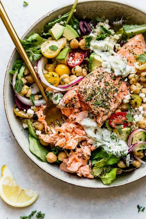 A healthy quinoa bowl complete with lemon-herb marinated salmon, garbanzo bean salad, tender quinoa, crisp greens, feta cheese, kalamata olives, and topped with homemade Tzatziki. This Mediterranean Bowl with Salmon is hearty, healthy, delicious, and makes for the perfect prep-ahead meal. It's a balanced bowl including a great source of quality protein, healthy fats, and fiber. || The Real Food Dietitians || Garbanzo Bean Salad, Mediterranean Bowl, Garbanzo Beans Salad, Salad Bowl Recipes, Mediterranean Bowls, Salmon Quinoa, Real Food Dietitians, Garbanzo Bean, Healthy Quinoa