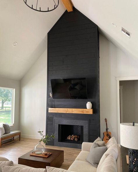 Black floor to ceiling shiplap fireplace is finished with a light wood mantel and flat panel TV. A square stained wood coffee table in front of the fireplace is framed by a beige sectional couch. Black Brick Fireplace, Design Camino, Cottage Fireplace, Black And White Living Room, Black Fireplace, White Shiplap Wall, Shiplap Fireplace, White Fireplace, White Shiplap