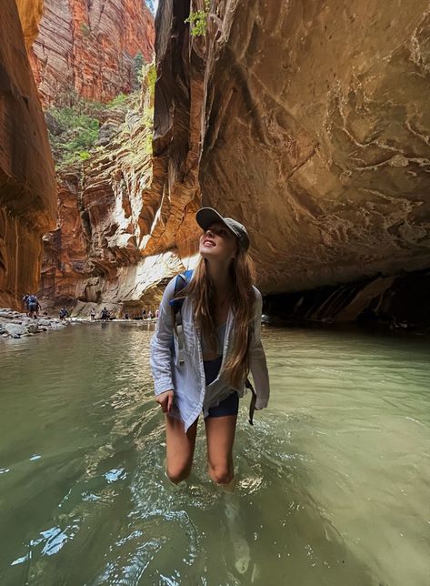 Girl hiking through water in Zion national park looking up smiling Zion National Park Poses, Zion National Park Picture Ideas, Zion Hiking Outfit, Zion National Park Outfit, Arizona Outfits Summer, Zion National Park Winter, Arizona Hiking Outfit, Fall Camping Outfits, Hiking Picture Ideas