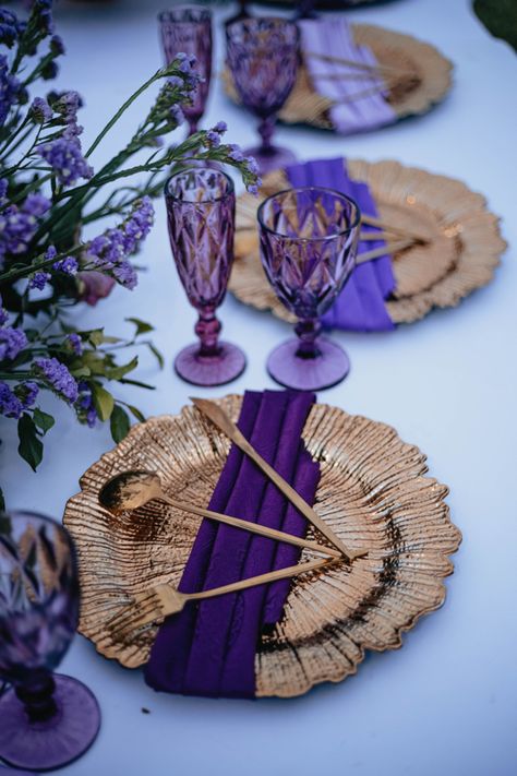 I placed three shades of purple and complimented with Purple shaded Glassware and blended up with Gold. Purple And Gold Event Decor, Purple And Rose Gold Party, Royal Blue Purple And Gold Wedding, Purple And Gold Wedding Theme Decor, Purple Gold Birthday Party Decoration, Royal Purple And Gold Wedding Theme, Purple And Gold Party Decorations Ideas, Dark Purple And Gold Wedding, Gold Chargers Place Setting