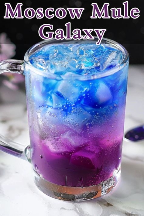 The Moscow Mule Galaxy is a vibrant twist on the classic Moscow Mule, featuring butterfly pea tea ice that adds a striking color-changing effect. Galaxy Drinks Cocktails, Galaxy Cocktail, Galaxy Cocktail Recipe, Winter Vodka Cocktails, Vodka Cocktails Easy, Butterfly Pea Tea, Summer Vodka Cocktails, Butterfly Tea, Pudding Shots