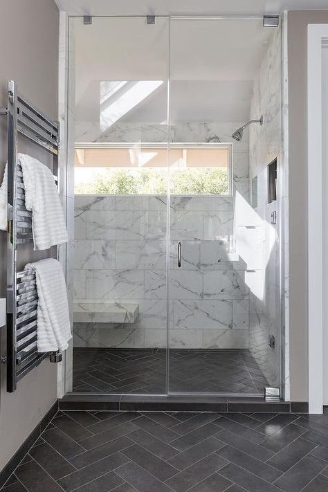 Slate herringbone pattern floor tiles in a transitional bathroom includes a seamless glass shower with large white and gray marble staggered wall tiles. Floor Herringbone Pattern, Pattern Floor Tiles, Floor Herringbone, Dark Tile Floors, Grey Bathroom Floor, Slate Bathroom, Design Interior Baie, Bathroom Dark, Dark Gray Bathroom