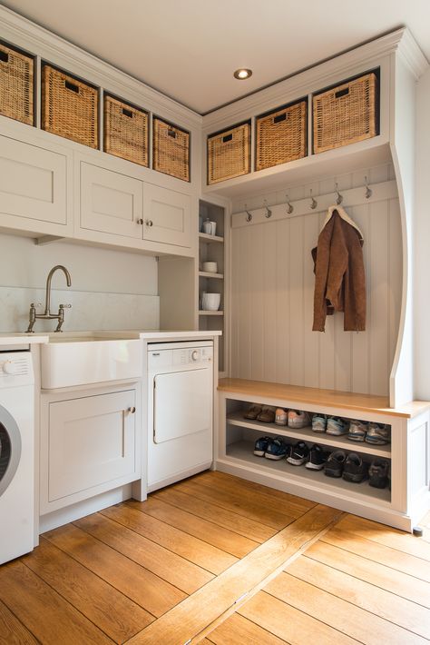 In this utility boot room has been designed with storage in mind. The upper tier cabinets were designed to take a selection of storage baskets, while the tall counter slim cabinet sits in front of a pipe box and makes a great storage space for the client's selection of vases.  Shoes are neatly stored out of the way with a bench in Oak above for a seated area. Mudroom And Laundry Room Combo, Shelves Laundry Room, Basement Mudroom, Utility Boot Room, Laundry Room Idea, Laundry Room Combo, Boot Room Utility, Modern Laundry Room, Country Laundry Rooms