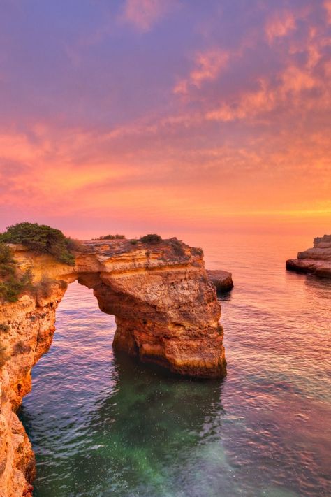 A beautiful sunset with purples, pinks and oranges over a seascape with aqua waters and a rock arch. Portugal Wallpaper, Portugal Sunset, Water Images, Algarve Portugal, Holiday Villa, Luxury Villas, Portugal Travel, Sunset Sunrise, Villa Rental