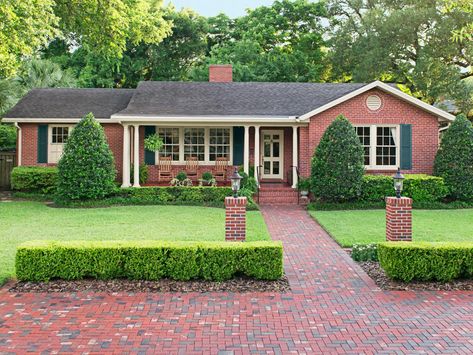 Built in: 1940. Bought in: 1996. Size: 3,000 sq. ft. "Only two families owned this house before us, and its charm is still very much intact," says homeowner Teresa Wood. "The traditional red-brick facade and spacious front porch remind my husband, Joe, of his childhood home." By extending the walkway into a brick parking pad, the Woods created space for cars without compromising the house’s character. Ranch House Landscaping, Curb Appeal Porch, Brick Ranch Houses, House Lighting Outdoor, Ranch House Exterior, Florida Landscaping, Ranch Remodel, Ranch Exterior, Hardscape Design