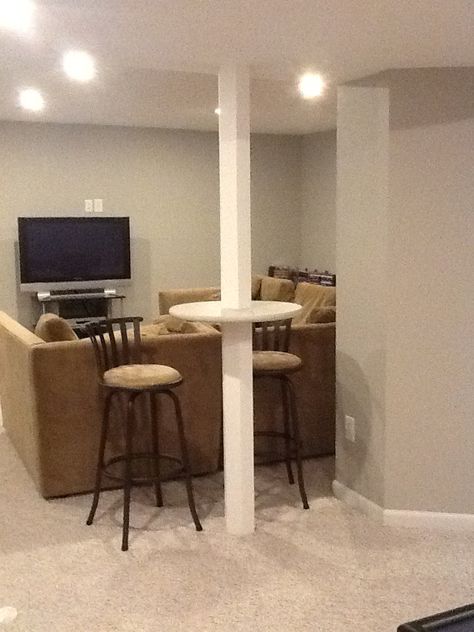 Basement support pole, bar height table.  Wood Basement pole wrap preconstucted cut at bar height and circle wood cut in half and fit around pole and glue all in place and paint Comfy Basement, Basement Column Ideas, Basement Pole Wrap, Basement Pole Covers, Basement Window Replacement, Basement Poles, Column Ideas, Basement Layout, Man Cave Basement