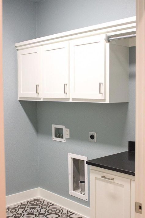 A laundry room with blue walls, white cabinets, and gray tile floor. #laundryroombasement Gray Tile Floor, Room With Blue Walls, Grey Tile Kitchen Floor, Grey Kitchen Tiles, Room Tiles Design, Blue Kitchen Walls, Laundry Room Paint Color, Laundry Room Paint, Grey Laundry Rooms