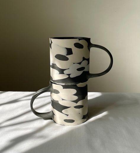 Introducing the stunning black-n-white Nerikomi floral mug - a work of art that brings beauty and functionality to your daily routine.  This one-of-a-kind mug is carefully crafted using the Nerikomi technique,  where colors and patterns are carefully mixed and arranged to create a unique design.  The delicate floral pattern on this mug is sure to captivate your heart,  and its sturdy build ensures that it will be your favorite mug for years to come. Dimension： 7.5 * 7.5 * 8.5 cm ( Holds about 300 ml ) * Hand-washing is highly recommended for handmade porcelain/stoneware. * Remember to keep the porcelain ware dry after washing.  * Due to the nature of all handmade goods, no two items are exactly alike, please note that before purchase. Black Porcelain, Black Clay Ceramics, Pottery Black Clay, Black And White Glazed Pottery, Porcelain Cup Handmade, Black Ceramic Mug, Ceramic Cafe, Mug Design, Black Clay