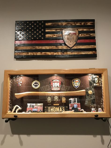 Firefighter shadow boxes and firefighter flag Firefighter Display Ideas, Firefighter Office Ideas, Firefighter Home Decor Ideas, Fire Department Shadow Box Ideas, Firefighter Decor House, Firefighter Decorations, Firefighter Man Cave Ideas, Firefighter Display, Firefighter Flag