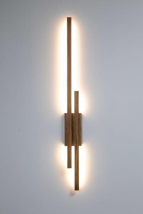 minimalist wooden linear wall lamp ambient light WAND TWO Modern Oak high quality handcrafted  WAND TWO lamp is a minimalist wall lamp with a simple and modern design. It consists of a long and short, horizontal wooden elements that attaches to a square bracket, which serves as the wall mount. The lamp emits soft, warm light directed downward, creating a gentle illumination effect on the wall below. The entire construction has a sleek, contemporary appearance and is made from natural oak wood, g Feature Wall Light, Wand Lamp, Living Room Wall Lighting, Wall Bracket Light, Living Room Wall Lights, Ambient Lamp, Wooden Wall Lamp, Wood Wall Lamp, Wood Lighting