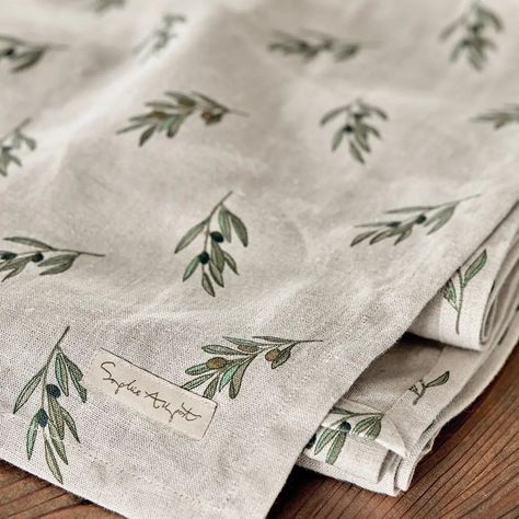 Description This beautiful table runner is made from 100% linen and is sure to add charm and warmth to table settings and dinner parties all year round. Featuring Sophie's dainty olive branch illustrations with delicious black olives and green and silvery blue leaves on a rustic neutral background, which will pair excellently with many interiors. Linen is known for its strength and durability and is also hypoallergenic, making it suitable for those with allergies and sensitive skin. It's also na Linen Placemat, Rustic Table Runner, Embroidery Napkins Table Linens, Kitchen Napkins, Olive Branch Embroidery, Table Linen Ideas, Table Linen, Table Runner Ideas, Baby Dress Embroidery