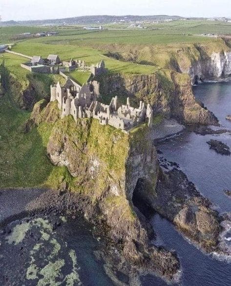 Dunluce Castle, perched dramatically on a cliff overlooking the North Atlantic Ocean in Northern Ireland, is a medieval fortress with a captivating history.  Originally built in the 13th century, the castle is renowned for its stunning and precarious location.  Its strategic position made it a significant stronghold during the medieval period, but it was abandoned in the 17th century due to damage from storms and economic decline.  Dunluce Castle stands as a picturesque and hauntingly beautiful rui Castle By The Ocean, Medieval Traveler, Castles Aesthetic, Castle On A Cliff, Cliff Castle, Ocean Castle, Castle On A Mountain, Castle By The Sea, Inside Castle