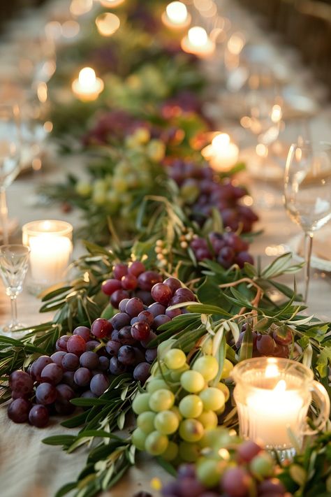 ✨ Elevate your wedding ambiance with a centerpiece that whisks you away to the rolling hills of Tuscany. Experience the charm of Italy as grape vines & olive branches intertwine with the warm glow of candles on your special day. #WeddingInspiration #TuscanWedding #RomanticDecor #WeddingIdeas #CountryChic #RusticElegance #GrapeAndOlive #CandlelightMagic Let the light guide your love story. Olive Flower Arrangement, Tuscan Themed Wedding Reception, Grapes On Wedding Table, Grape Decorations Party, Bread Wedding Centerpieces, Tuscany Table Decor, Wedding Table Olive Branch, Grape Centerpiece Wedding, Olive Branches Decor