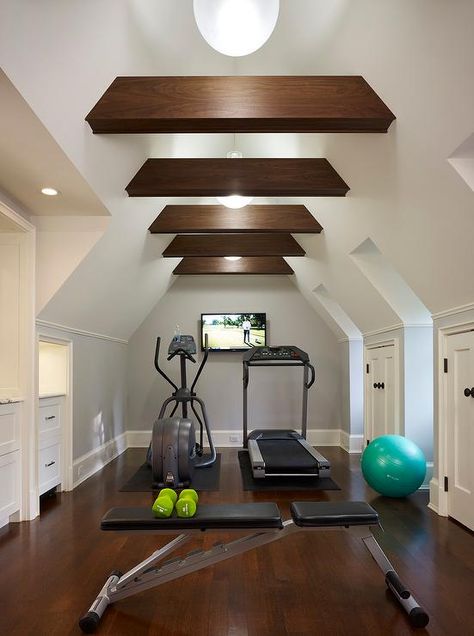 Attic home gym boasts a vaulted cieling adorned with wood beams placed over gym equipment facing a flat panel tv. Home Gym Closet, Gym Closet, Attic Library, Attic Renovation Ideas, Finished Attic, Media Room Design, Attic Playroom, Exercise Room, Reformer Pilates