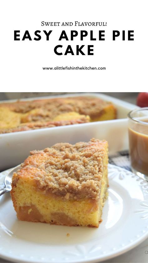 A streusel-topped piece of yellow cake is on a small white plate. Pieces of apple are visible at the bottom of the cake slice. A cup of coffee is on the side and the baking dish with the cake is slighly blurred in the background. Easy Apple Pie Cake Recipe, Super Creamy Apple Pie Cake, Dutch Apple Cake Recipe, Apple Pie Cake Recipe Easy, Apple Filling Cake, Applecake Cake, Apple Pie Cake Recipe, Pie Cake Recipe, Desserts Board