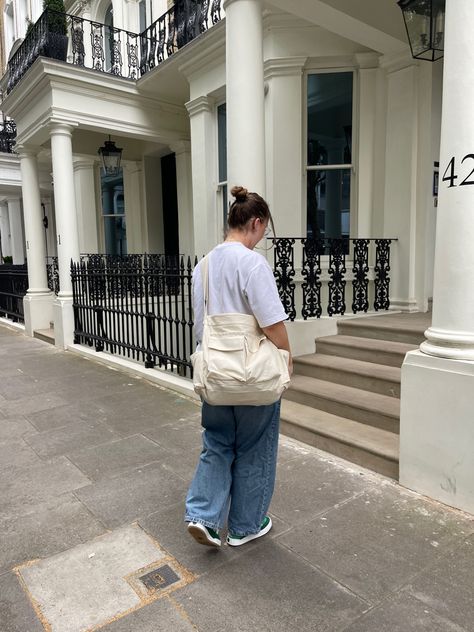 Young woman wearing a casual outfit with a white tee shirt, denim baggy jeans, and green adidas adimatic in the street of London Aesthetic Sling Bag Outfit, Y2k Sling Bag, Louis Vuitton Avenue Sling, Large Capacity Nylon Sling Bag, Sling Bag Outfit, Gorpcore Sling Bag, Amsterdam Winter, Night Vibes, Winter Fits