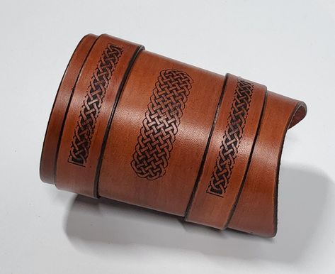 Hand crafted leather wrist cuff with 3 Celtic pattern engraving. This item was hand made in our small workshop in Dorset England. Each of our wrist cuffs are unique in there design and no two cuffs will be the same due to the way we make each one individually. So you can buy with the confidence that you will not only have something made to a very high standard. Its also a one of a kind unique item only you have. This wrist cuff is made from genuine leather with all the edges hand dyed and burnished. This is not only for the appearance of the leather, but to help protect it. The cuff comes with full roller buckles which are nickel plated steel (silver). They are not only very stylish but incredibly hard wearing, The dimensions for the cuff are as follows. Width of main body 11cm (4.5") Leng