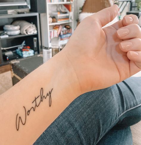 Script tattoo worthy Beauty Word Tattoo, Hand Script Tattoos For Women, You Are Worthy Tattoo Fonts, I'm Worthy Tattoo, Power Word Tattoo, Side Wrist Tattoos For Women Words, Wrist Script Tattoos For Women, Worthy Tattoo Fonts, Script Wrist Tattoo